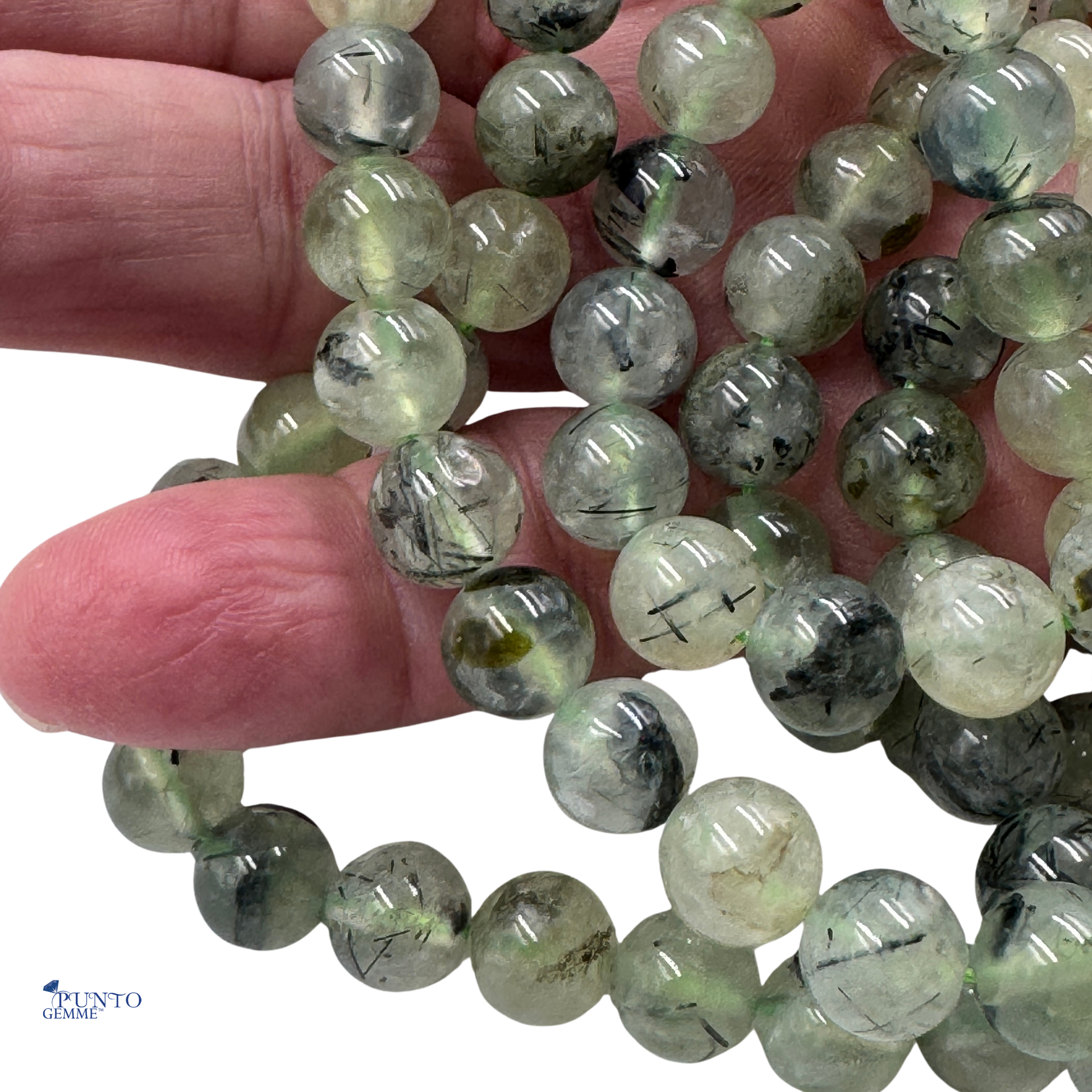 Scatto macro di perle tonde in Prehnite, la pietra che calma e riduce il bisogno di controllo (Pietra della Memoria).