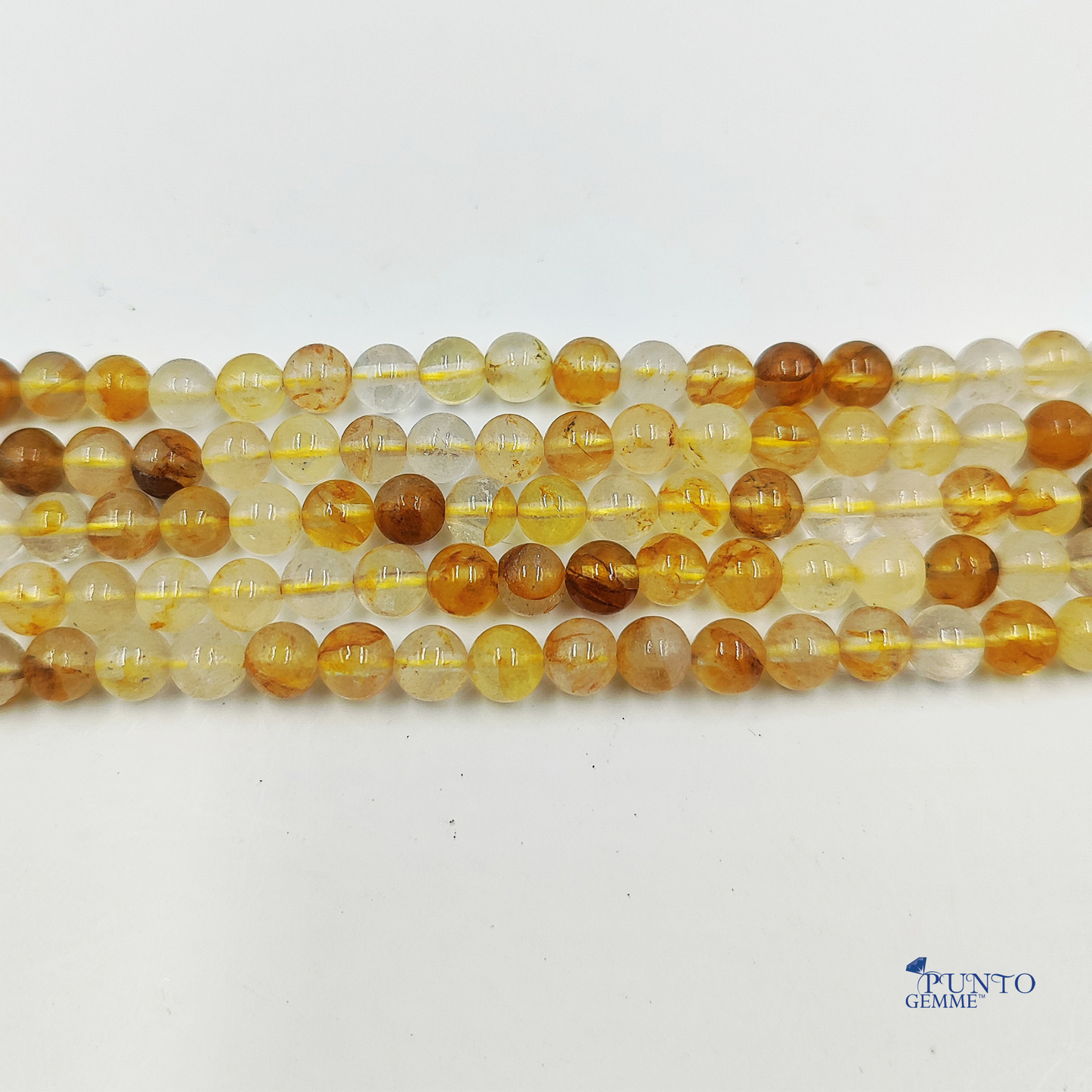 Primo piano di perle che mostra il contrasto tra il quarzo chiaro e l'inclusione Limonite scura.