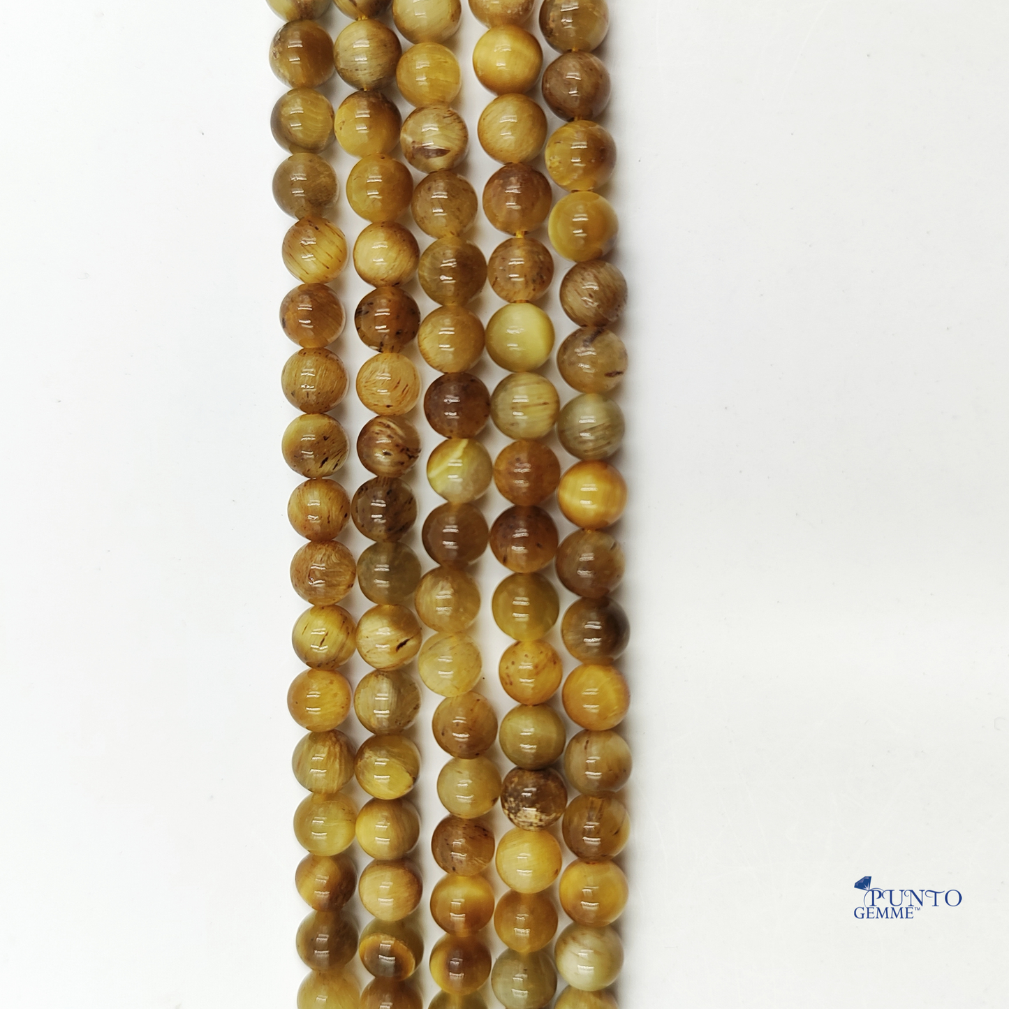 Dettaglio macro di una perla di Occhio di Tigre 6mm che cattura il riflesso della luce.