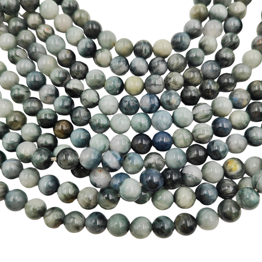 Primo piano del filo di Occhio d'Aquila, perle 8 mm lisce che mostrano l'effetto cangiante grigio-blu.