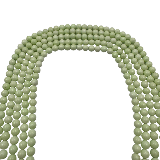 Primo piano del filo di Crisoprasio Australiano , perle tonde lisce che mostrano il brillante colore verde mela.