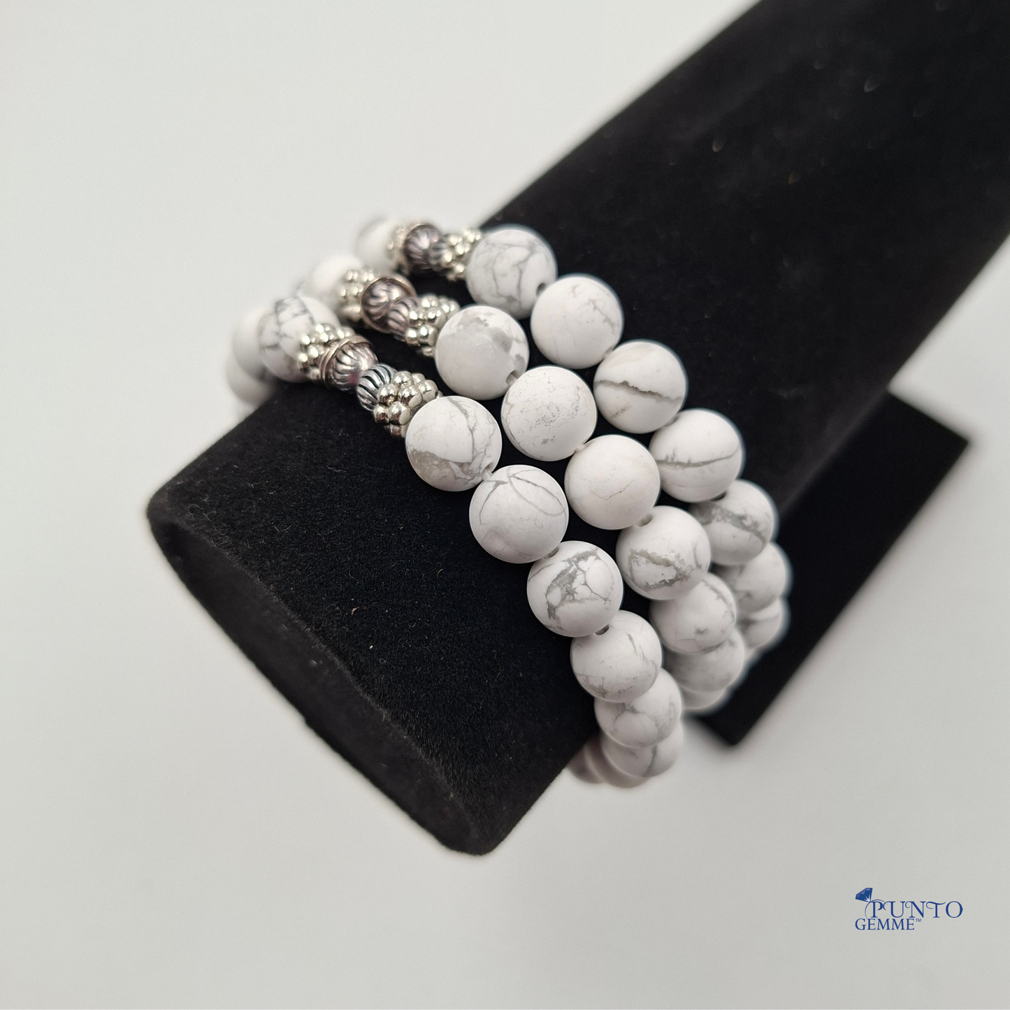 Scatto del bracciale elastico Howlite arrotolato su uno sfondo chiaro, enfatizzando l'effetto marmorizzato.