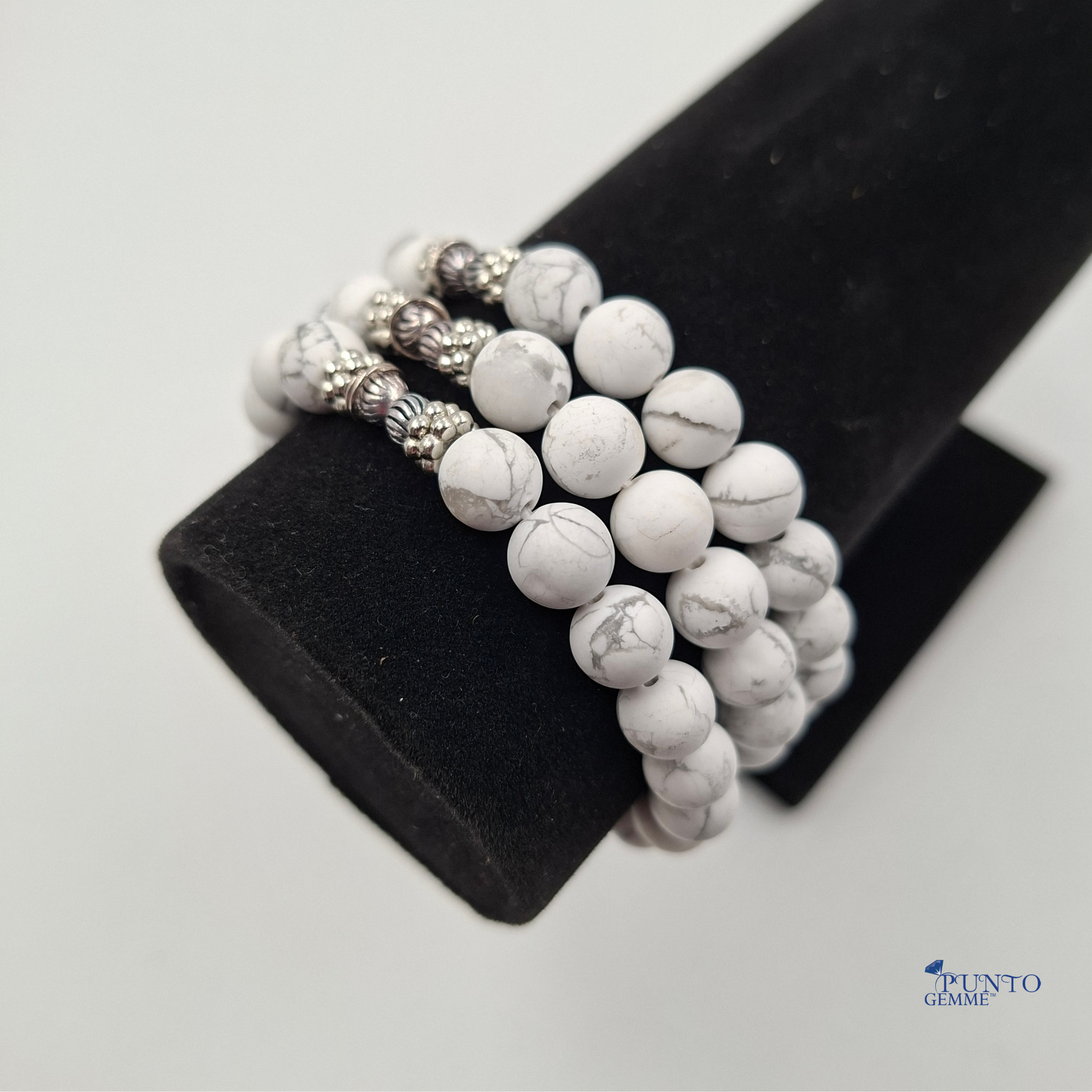 Scatto del bracciale elastico Howlite arrotolato su uno sfondo chiaro, enfatizzando l'effetto marmorizzato.