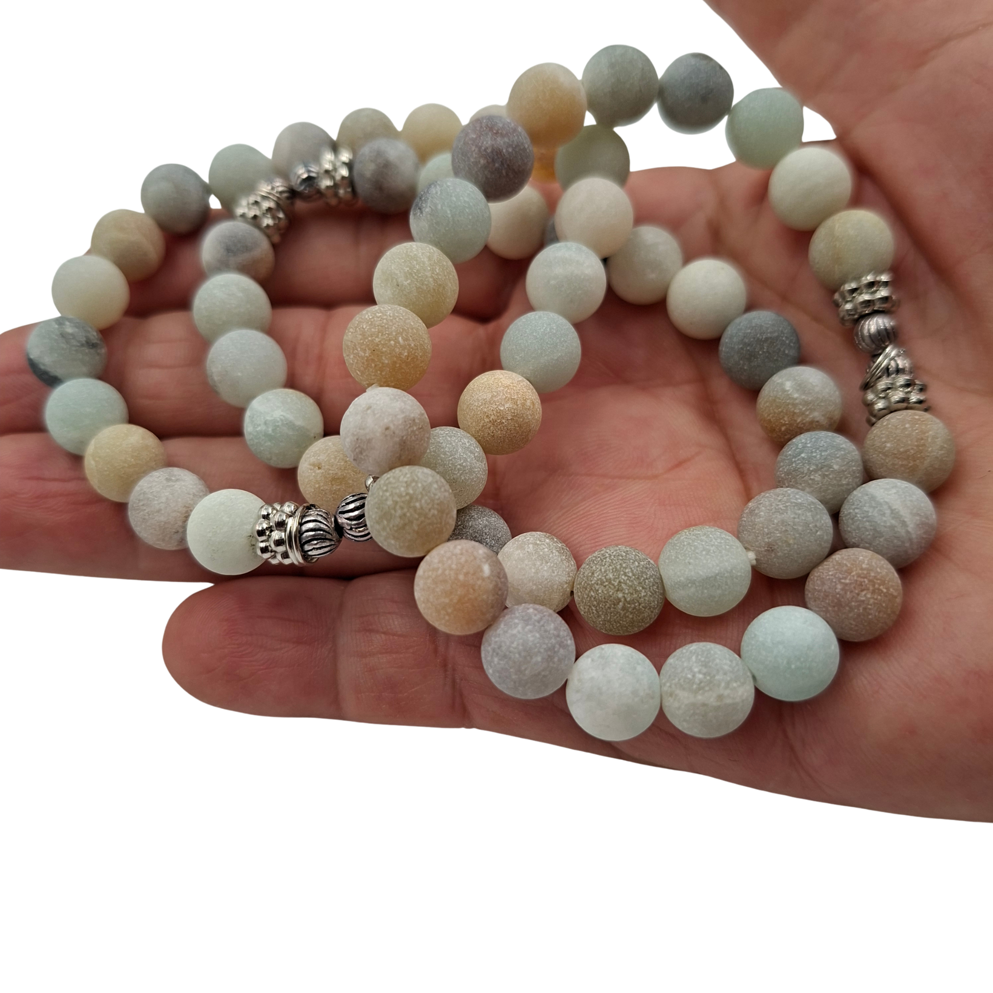 Dettaglio ravvicinato delle perle di Amazzonite e dell'inserto metallico, evidenziando i colori tenui