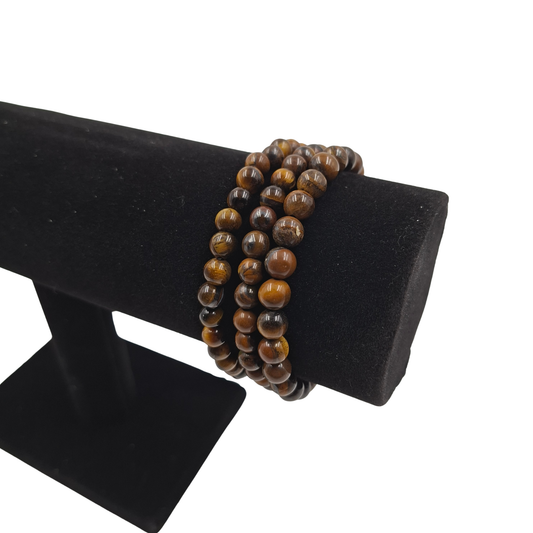 Il bracciale in Occhio di Tigre indossato su un polso, evidenziando il taglio da e i riflessi luminosi marrone-dorati.