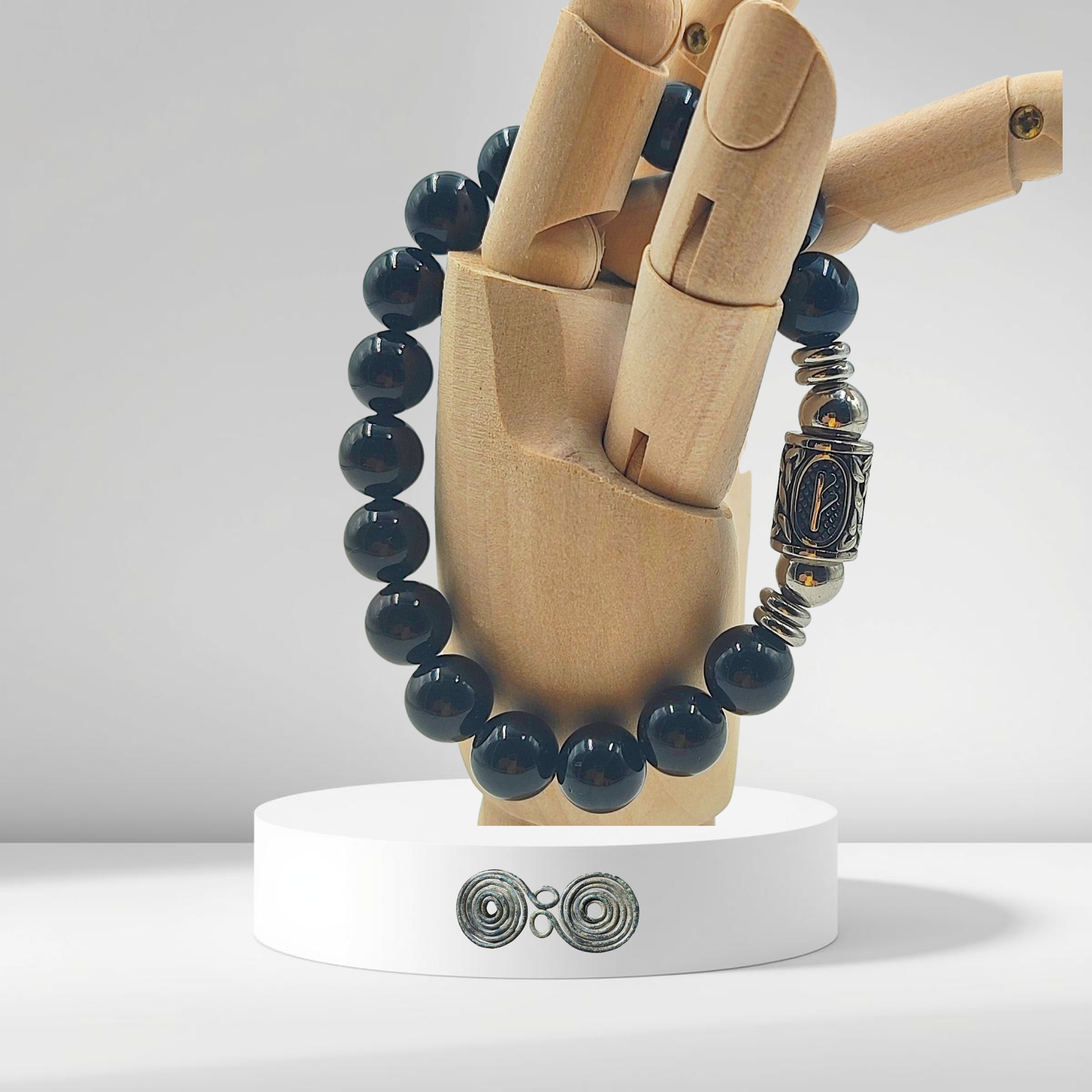 Dettaglio della runa norrena Fehu simbolo di ricchezza su pietra tormalina nera naturale. su mano.