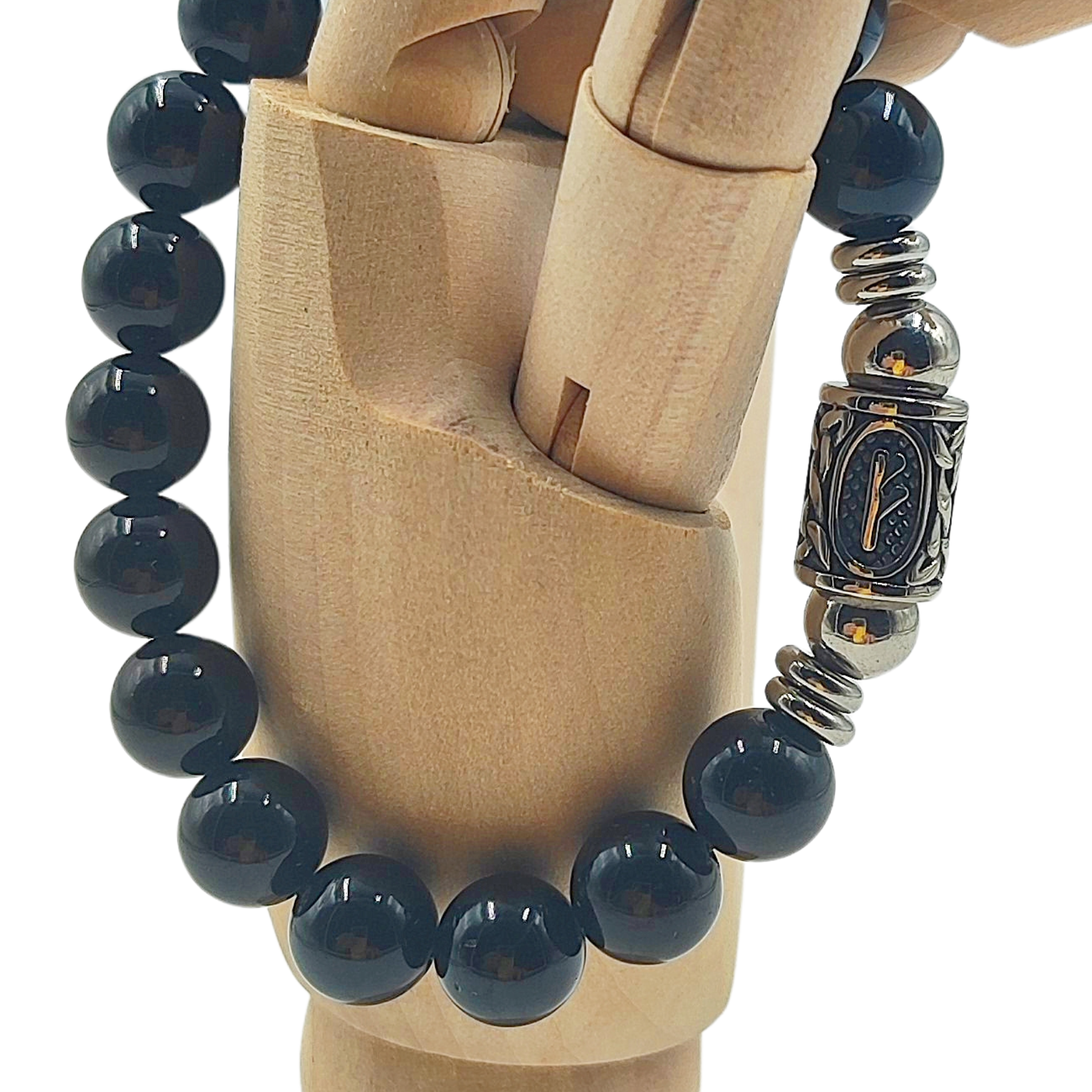 Dettaglio della runa norrena Fehu simbolo di ricchezza su pietra tormalina indossato su mano in legno