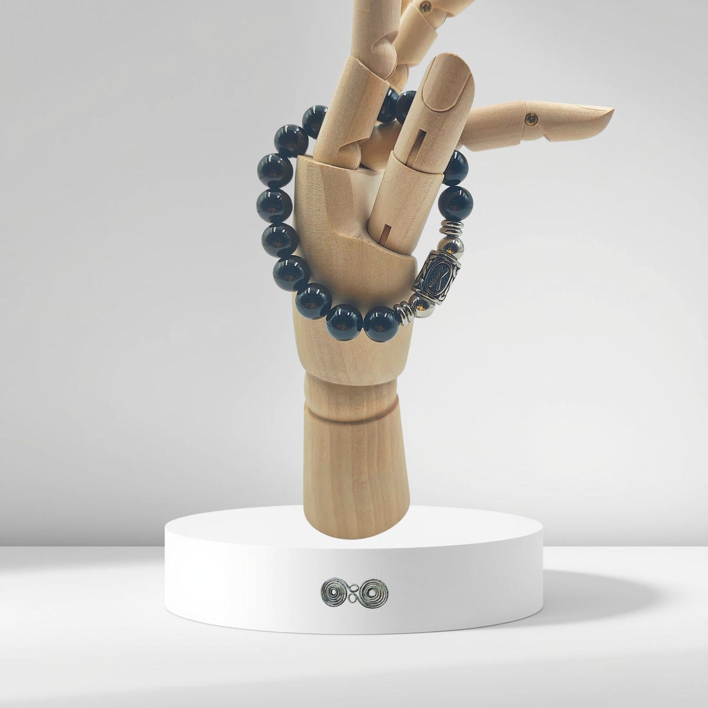 Bracciale Pietra Aurea PE8047 Runa Gebo e Tormalina Nera indossato su mano legno