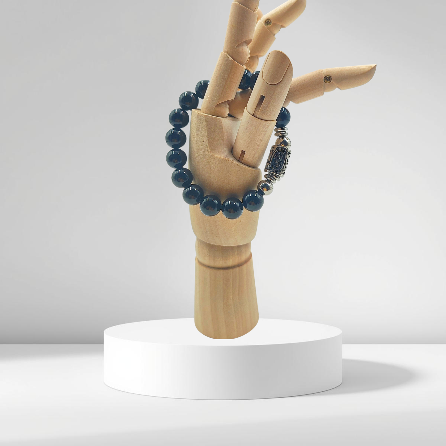 Bracciale PE8052 in Tormalina Nera con la runa Jera incisa, simbolo di abbondanza e cicli su modello in legno