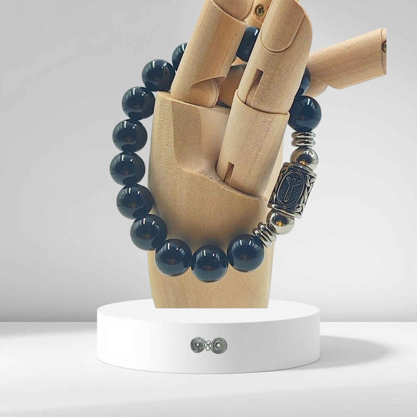 Dettaglio delle perle di Tormalina Nera 10 mm per mostrare la dimensione e la qualità su modello in legno