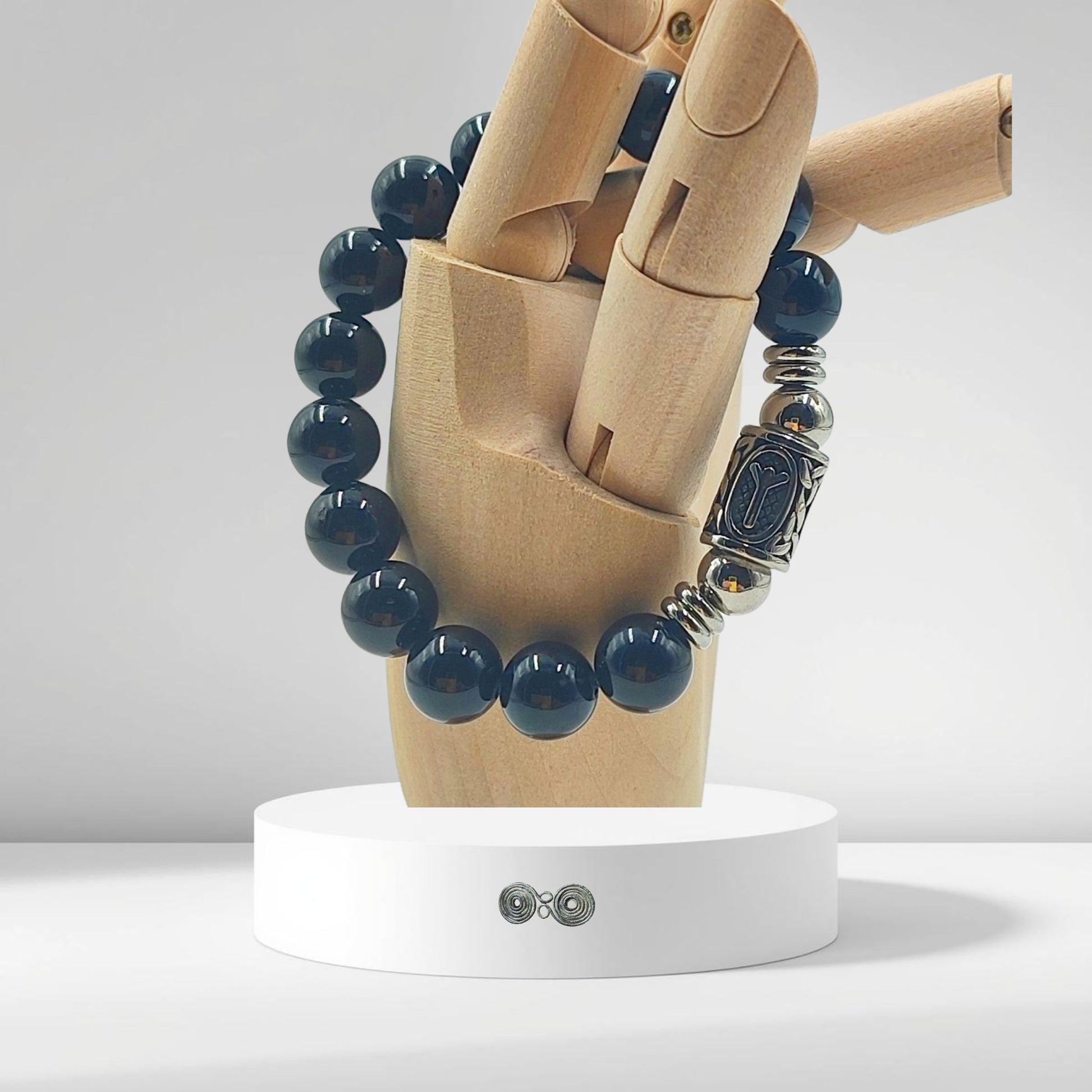 Dettaglio delle perle di Tormalina Nera 10 mm per mostrare la dimensione e la qualità su modello in legno