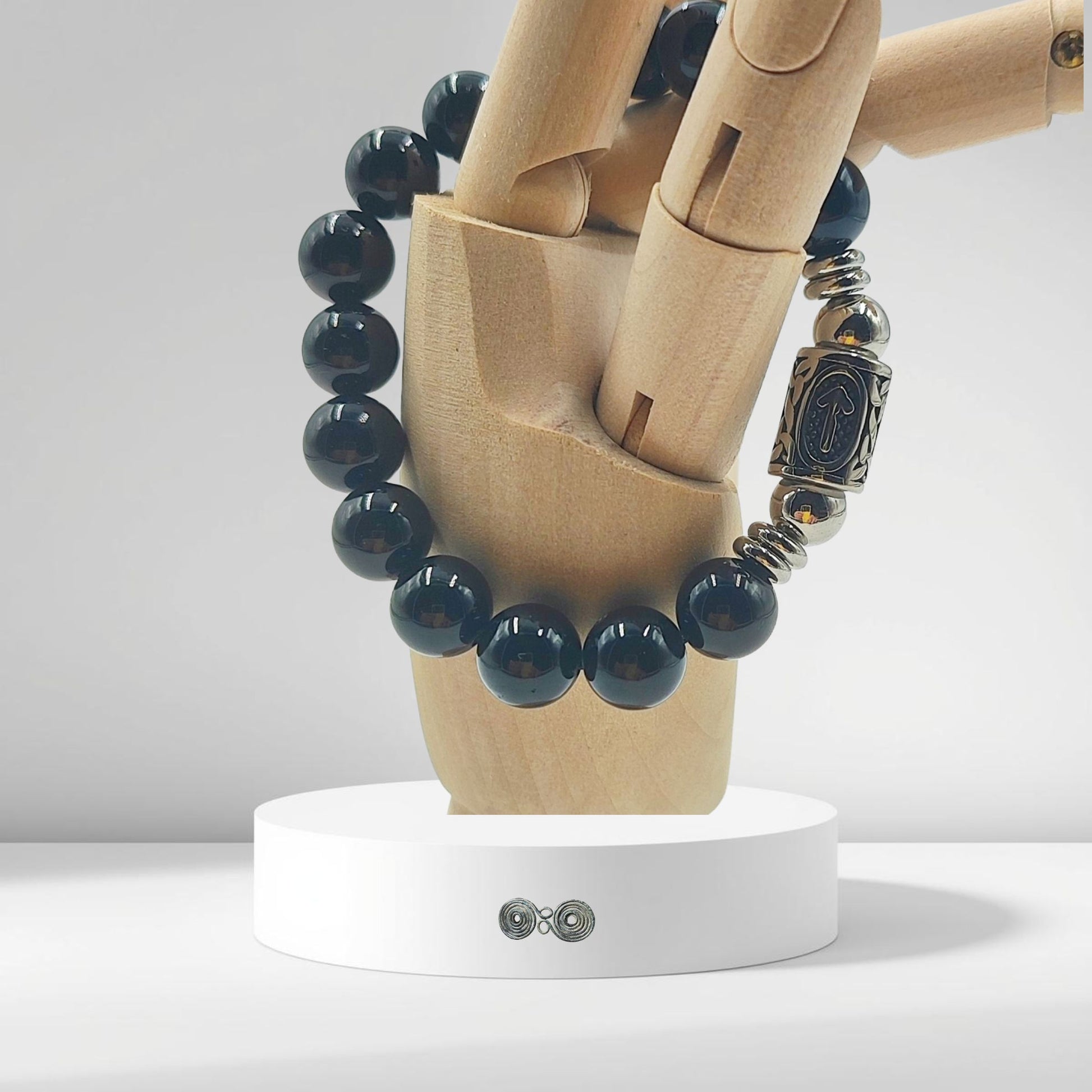 Dettaglio su mano in legno,  della runa norrena Tiwaz, simbolo di Tyr e della vittoria, su tormalina nera naturale.