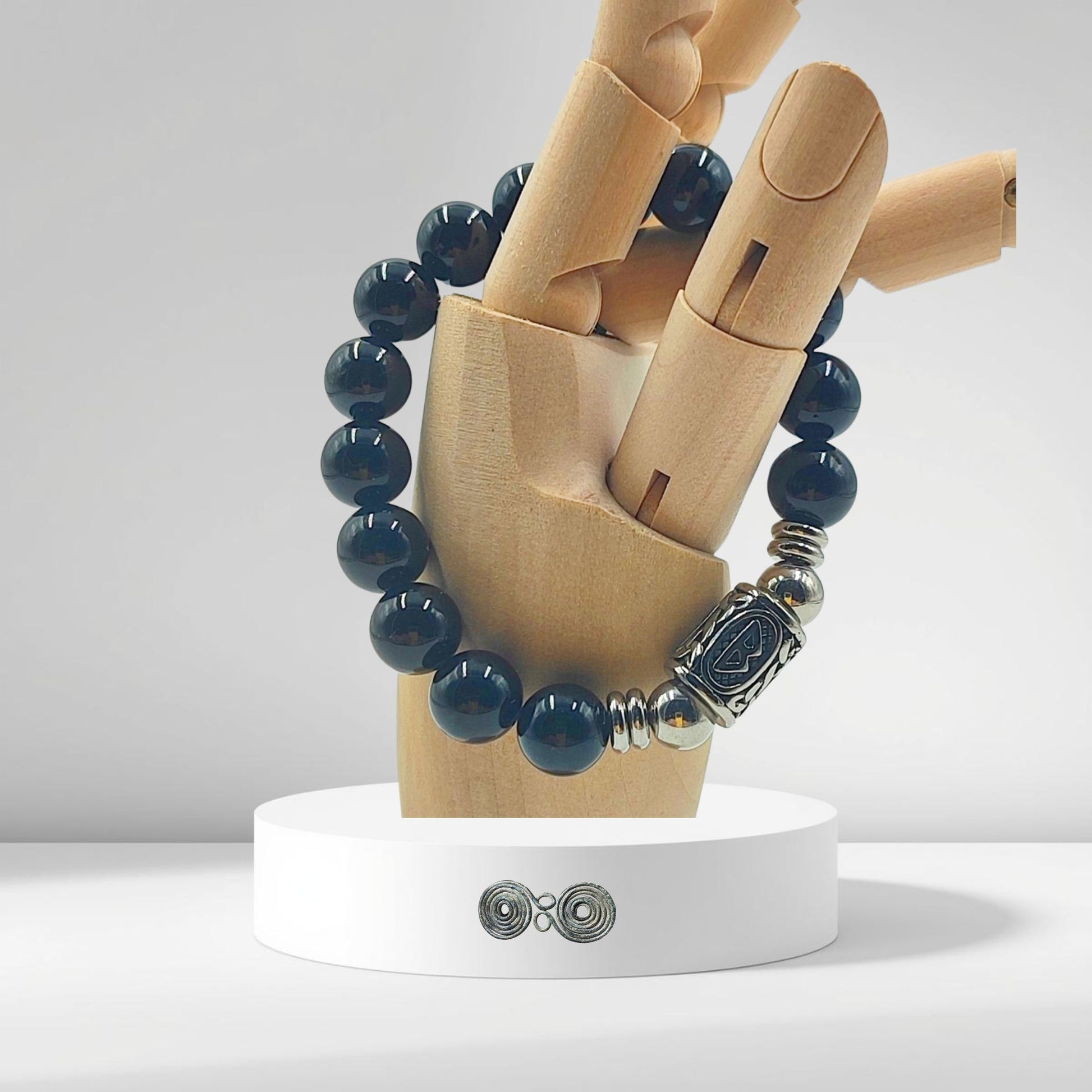 Dettaglio della runa norrena Berkana su una sfera di tormalina nera naturale da lotto certificato.