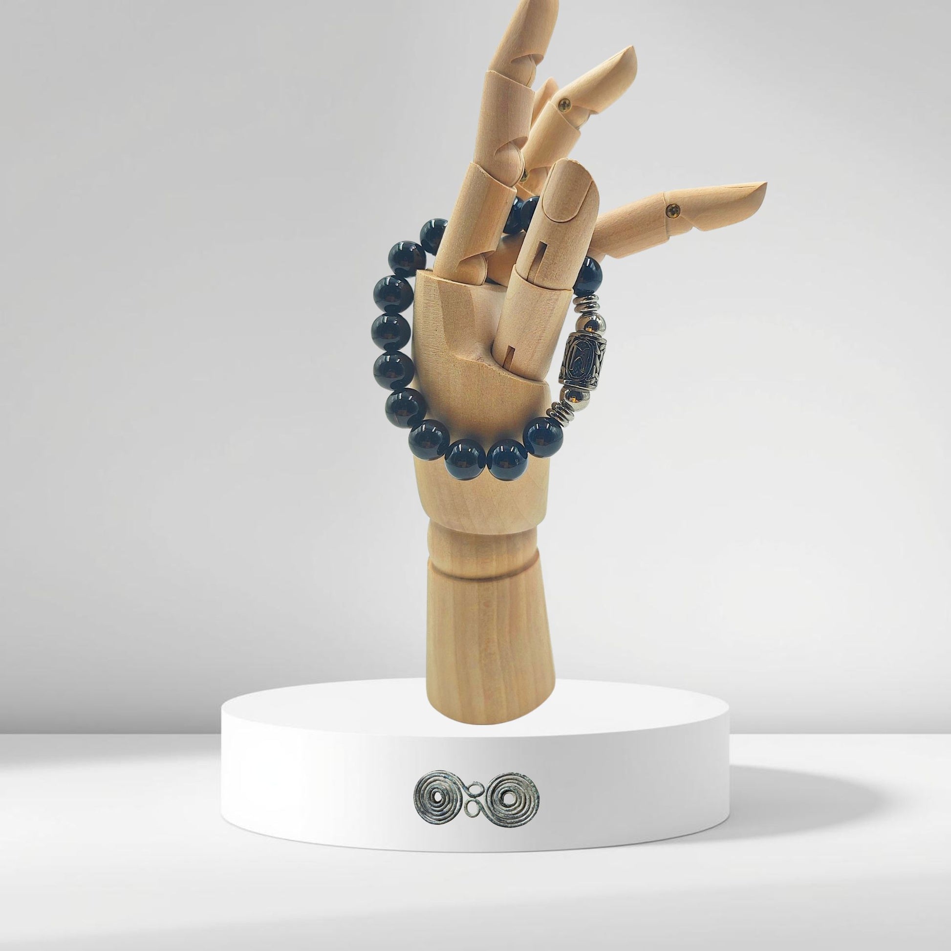 Bracciale in Tormalina Nera PE8065 con la runa Mannaz incisa, su modello mano in legno.