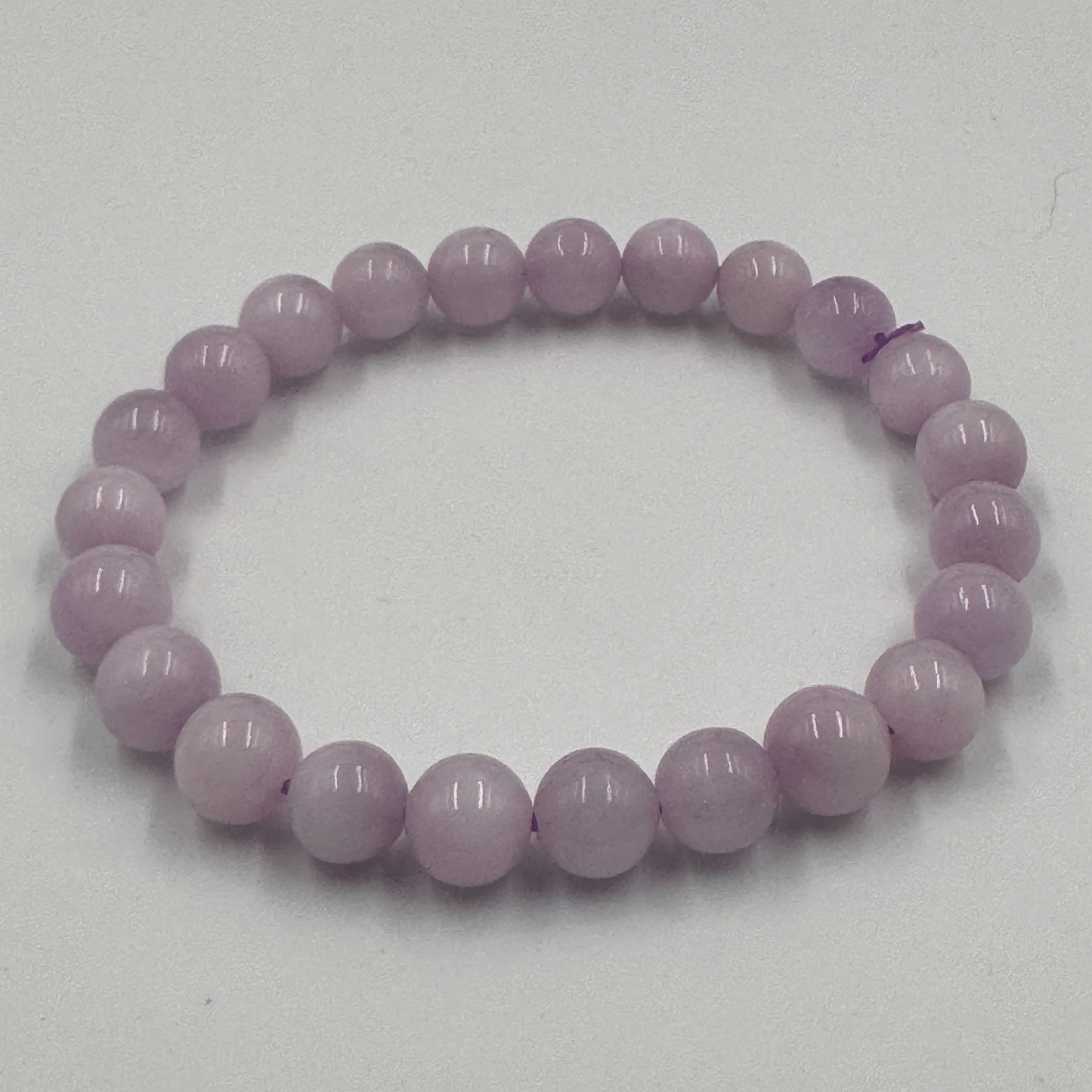 Bracciale in Kunzite PE6003 disteso su un panno di velluto bianco o rosa chiaro, evidenziando la qualità Top 100.